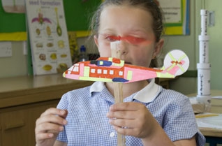 Young girl with a rubber band powered helicopter