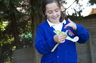 Girl winding the rubber band on a model helicopter