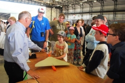 Model aircraft on table surrounded by adults and children